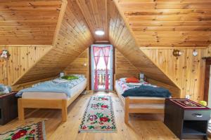 two beds in a room with wooden ceilings at Salerno camp in Plav