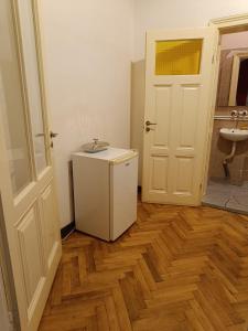 a bathroom with a white refrigerator and a sink at Micro Maxi House in Bela Crkva