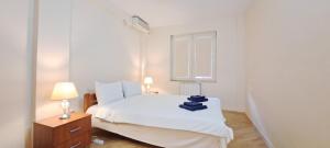 una camera da letto con un letto bianco e una finestra di Golden Delight Central Apartment a Skopje