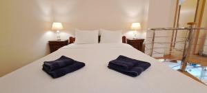 a bedroom with a white bed with two blue pillows on it at Golden Delight Central Apartment in Skopje