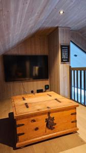 eine Holztruhe in einem Zimmer mit einem Flachbild-TV in der Unterkunft havsdalen 57 in Geilo