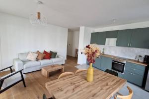 a living room with a vase of flowers on a table at Chic & Spacious 3-Bedroom with balcony in Saint-Ouen +9 photos