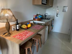 una cucina con tavolo, lampada e piano di lavoro di Flat Manacas Granja Brasil Itaipava a Itaipava