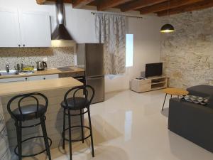eine Küche mit zwei Barhockern und einer Arbeitsplatte in der Unterkunft Apartman Martina in Sveti Filip i Jakov