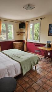 - une chambre avec un lit, une table et des fenêtres dans l'établissement Auberge la Table du Curé, à Cucugnan