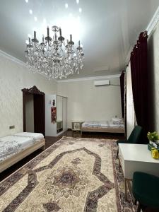 a bedroom with a chandelier and a living room at Sultan Saray in Osh