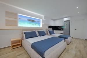 a bedroom with a large bed and a kitchen at Cako Rooms Saranda in Sarandë