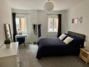 Emily Lane Apartments في بلفاست: غرفة نوم بسرير ومكتب ونوافذ
