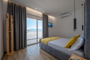 a bedroom with a bed and a large window at Cako Rooms Saranda in Sarandë