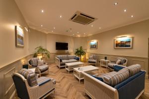 a waiting room with couches and chairs and a flat screen tv at The Royal Duchy Hotel in Falmouth
