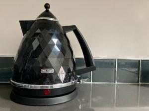 a black tea kettle sitting on a kitchen counter at Cathedral Quarter Apartments in Belfast