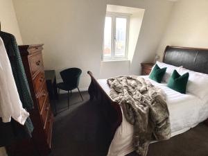sypialnia z dużym łóżkiem z zielonymi poduszkami w obiekcie Cathedral Quarter Apartments w mieście Belfast