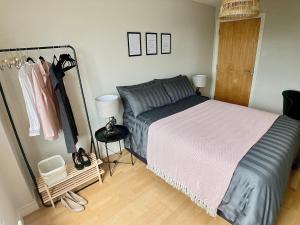 um quarto com uma cama e um cabide de roupas em Little Victoria Apartments em Belfast