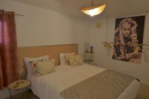 a bedroom with a bed and a picture of a woman at Evasion in Aigues-Mortes