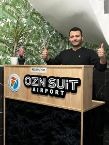 Un uomo è in piedi dietro un podio di Ozn Suit Airport a Arnavutköy