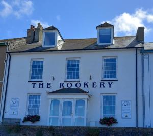 Un edificio blanco con el cartel de Roodery. en The Rookery, en St Ives