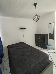 um quarto com uma cama, uma cómoda e um espelho em Monoambiente em San Luis Potosí