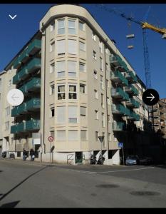 un grand bâtiment blanc avec une grue devant dans l'établissement Pina’s home, à Trieste