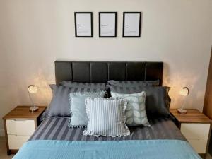 a bedroom with a bed with blue and white pillows at Hamilton Road Apartments in Belfast
