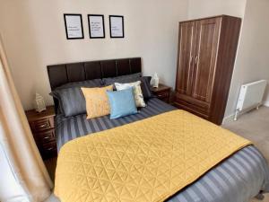 a bedroom with a large bed with a yellow blanket at Hamilton Road Apartments in Belfast