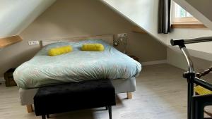 una camera da letto con un letto con due cuscini gialli di Op den Distelberg a Helvoirt
