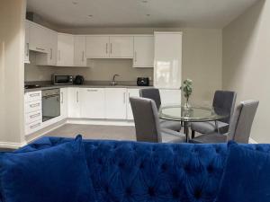 a living room with a blue couch and a table at Edward St Apartments in Belfast