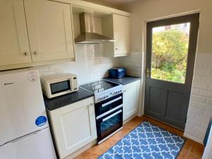 Una pequeña cocina con estufa y microondas. en Erin Way Apartments, en Belfast