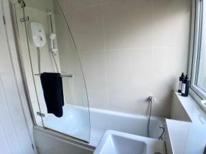 La salle de bains est pourvue d'une douche, d'un lavabo et d'une baignoire. dans l'établissement Erin Way Apartments, à Belfast