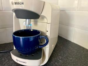 una cafetera con una taza azul encima en Erin Way Apartments, en Belfast 16 fotos más