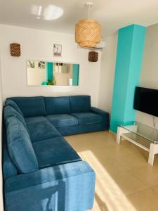 a living room with a blue couch and a tv at APARTAMENTO CENTRO 3 HABITACIONES CON AIRE ACONDICIONADO Y WIFI A 150m DE LA PLAYA in Peñíscola