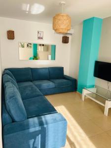 佩尼斯科拉APARTAMENTO SITUADO EN EL CENTRO CON 3 HABITACIONES, DISPONE DE AIRE ACONDICIONADO Y WIFI A 150m DE LA PLAYA Y EL CASTILLO的客厅里有一张蓝色沙发和一台电视