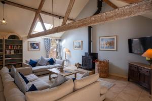 a living room with couches and a fireplace at Tern Place in Kelling