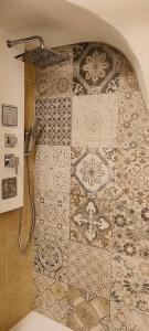 a bathroom with a shower with a tile wall at Residenza al Castello in Castellaro