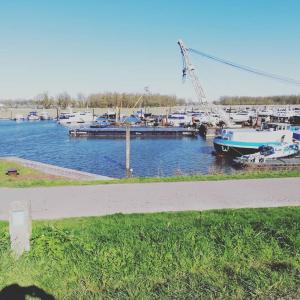 un puerto deportivo con barcos en el agua y una grúa en De Sleeuwijkerwaard, en Sleeuwijk