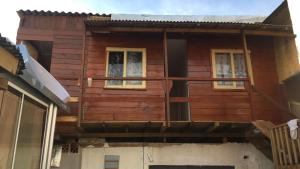 a wooden house with two windows and a porch at Quarto com Vista do Rio in Itajaí