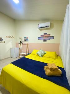 a yellow and blue bed in a room at Casa Silveira NORONHA in Fernando de Noronha