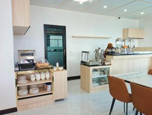 a kitchen with a counter with dishes on it at Remas Hotel Hatyai in Hat Yai