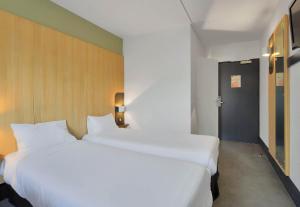 duas grandes camas brancas num quarto de hotel em B&B HOTEL Le Tréport Friville em Friville-Escarbotin