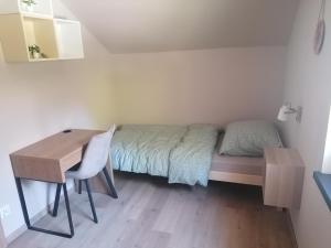 ein kleines Schlafzimmer mit einem Bett und einem Schreibtisch in der Unterkunft Dom wypoczynkowy Pod kasztanem 2 in Wartkowo