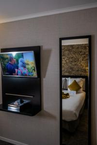 einen Spiegel in einem Hotelzimmer mit einem Bett in der Unterkunft Best Western Allegro Nation in Paris