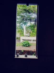 a window view of a park with a bench at Suíte Lazuli in Itaparica Town