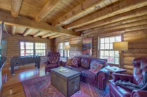 a living room with a couch and a pool table at Cozy Log Cabin Getaway with Fire Pit and 3 Acres! in Ruckersville