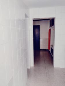korytarz z białymi ścianami i czarnymi drzwiami w obiekcie Suíte Lazuli w mieście Itaparica