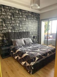 um quarto com uma cama com uma parede preta em Très bel appartement neuf à Mansbay Manssouria em Mohammedia