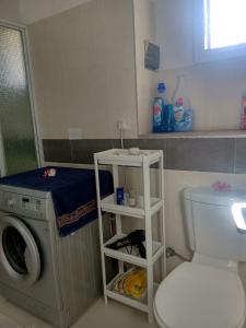 a bathroom with a toilet and a washing machine at Beautiful apartment in secured residence close to beach in Trou aux Biches +5 photos