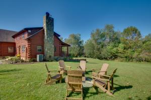 Cozy Log Cabin Getaway with Fire Pit and 3 Acres! في Ruckersville: مجموعة من الكراسي تجلس في العشب أمام المنزل