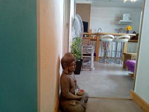 une statue assise au sol d'une pièce dans l'établissement Appartement Centre ville Terrasse, à Tarbes
