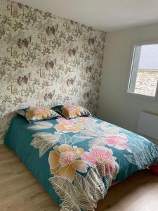 1 dormitorio con 1 cama con colcha de flores en A 15km du Mont-Saint Michel, en Saint-James