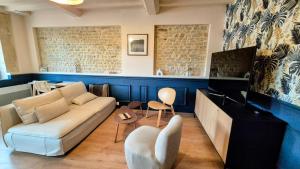 ein Wohnzimmer mit Sofa und Fernseher in der Unterkunft L'Arromanchaise - Gold Beach in Arromanches-les-Bains