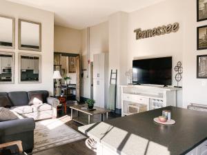 a living room with a couch and a table at Neyland View Condo - Heart of Downtown Knoxville in Knoxville